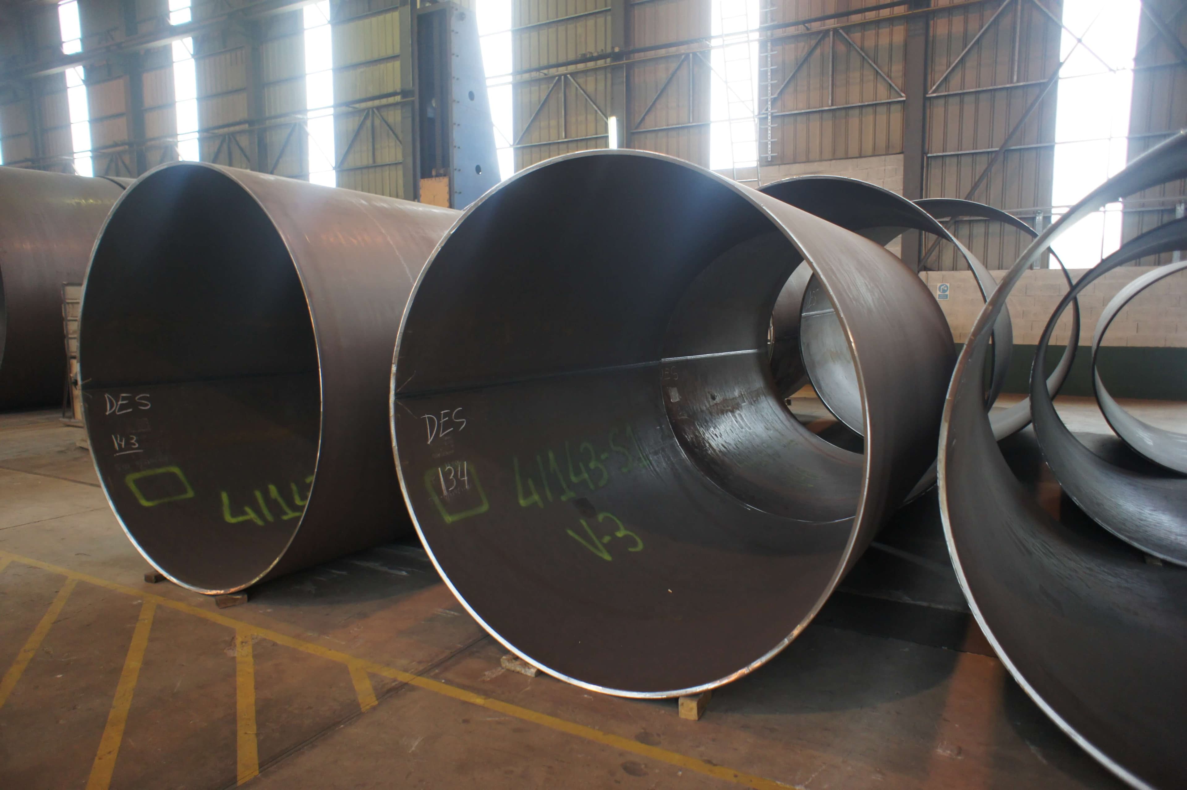 Viroles en tôle d'acier roulée portant leurs repères de fabrication, alignées dans l'atelier