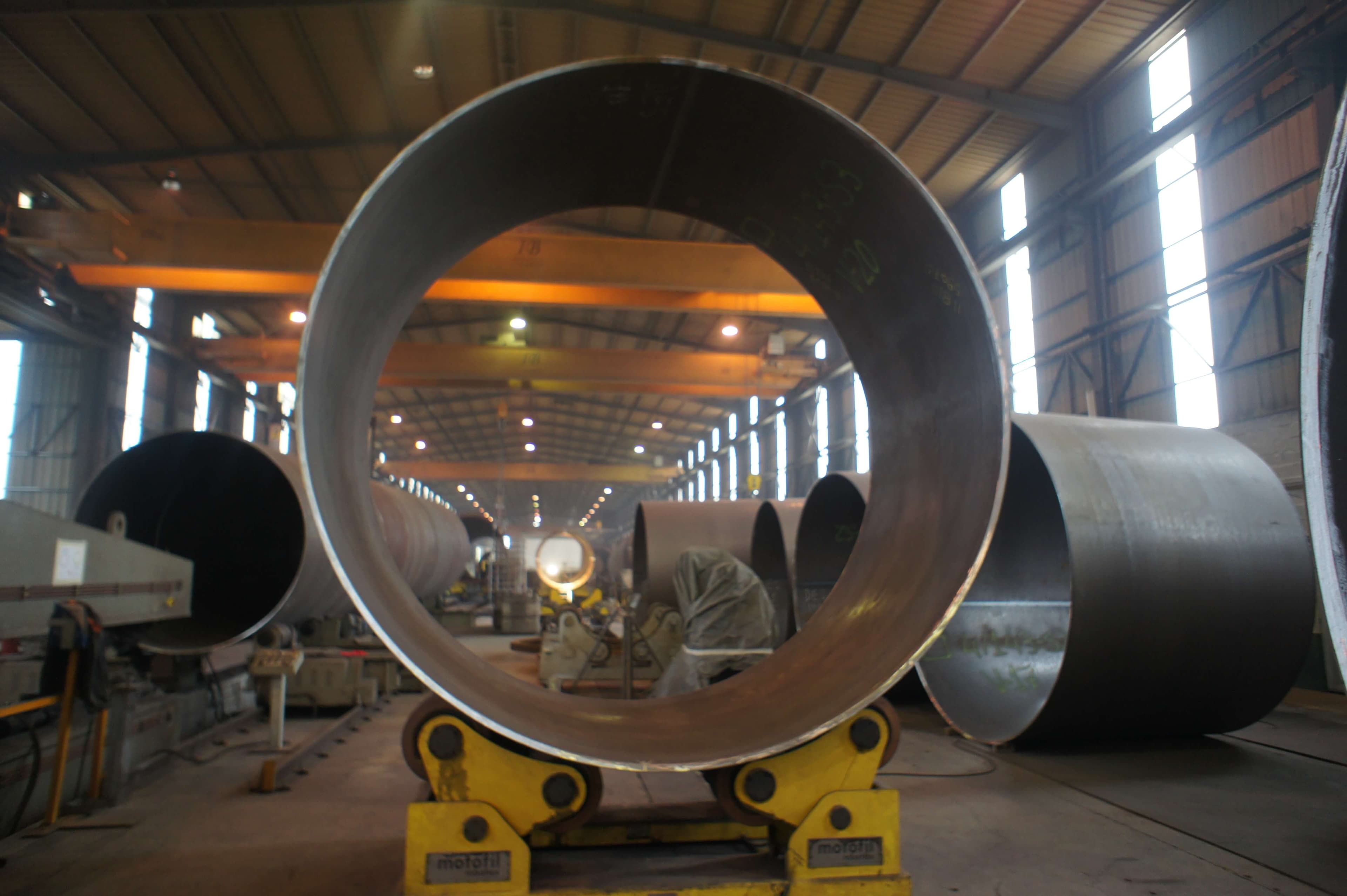 Grande virole en tôle d'acier roulée sur vireurs de soudage, en halle de chaudronnerie