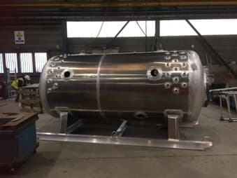 Coque de caisson hyperbare en métal brut, percée pour les hublots, sur châssis en atelier