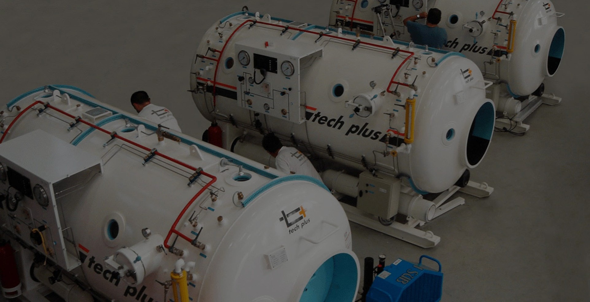 Trois caissons hyperbares Tech Plus en cours d'équipement par des techniciens, en atelier