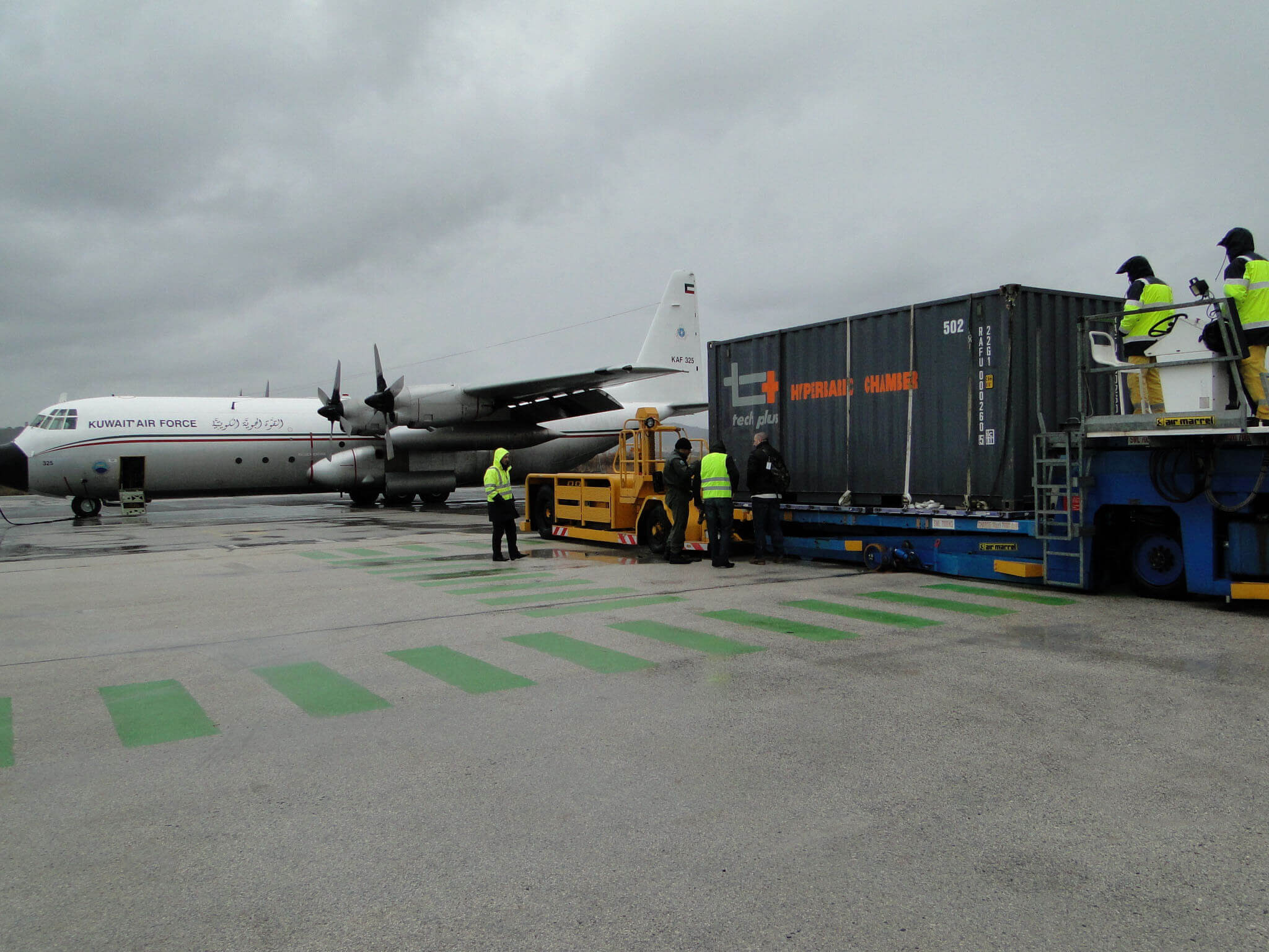 Caisson hyperbare projetable Tech Plus en conteneur, sur un chargeur près d'un avion de transport militaire