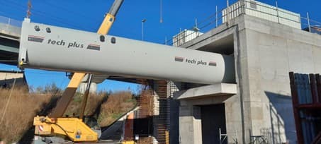 Grutage d'un long caisson hyperbare Tech Plus sur un chantier, près d'un ouvrage en béton